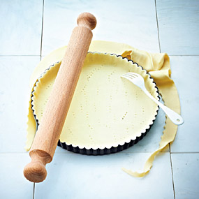 Kuchenboden aus Mürbteig in Kuchenform geben und mit Gabel einstechen.