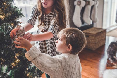 Kinder schmücken den Weihnachtsbaum | © Paige Cody, unsplash Kinder schmücken den Weihnachtsbaum | © Paige Cody, unsplash