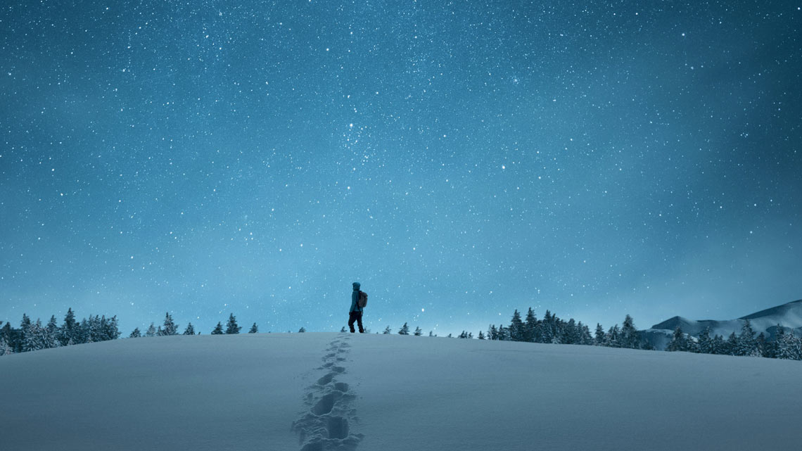 Wanderer in Schneelandschaft bei Nacht. | © New Africa / Shutterstock