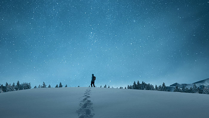 Wanderer in Schneelandschaft bei Nacht. | © New Africa / Shutterstock