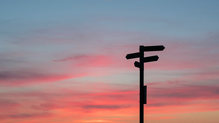 Wegweiserschild vor abendlichem Himmel. | © unsplash.com