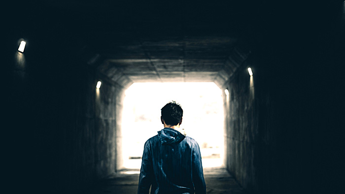 Person von hinten mit Blick auf erhellten Tunnel. | © unsplash.com