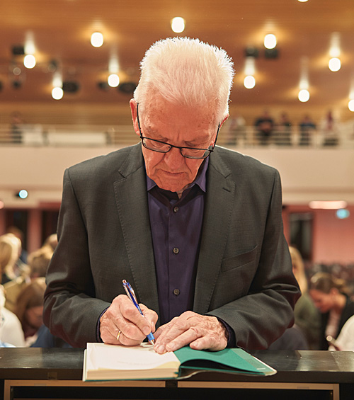 Winfried Kretschmann beim Signieren seines Buches. | © Ronny Schönebaum
