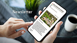 Frau liest einen Newsletter der Verlagsgruppe Patmos am Smartphone