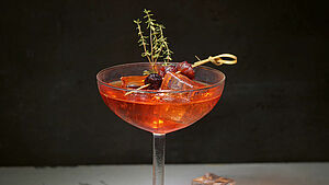Gefülltes Cocktailglas mit Cranberry-Clementinen-Spritz. | © Finken & Bumiller, Stuttgart