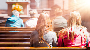 Menschen, die in einer Kirche beten | © Muratart / shutterstock.com
