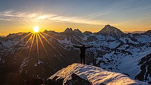 Ein Mann auf einem schneebedeckten Berg bei Sonnenaufgang | © Damian Markutt, unsplash