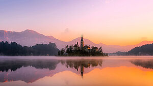 Kirchengebäude an einem See im Morgennebel. | © pixabay.com