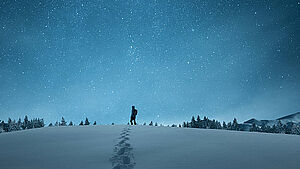 Wanderer in Schneelandschaft bei Nacht. | © New Africa / Shutterstock