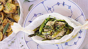 Fischpäckchen mit Kartoffeln angerichtet. | © Lena Fuchs