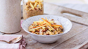 Eine Schale voll Birchermüsli mit Apfelspalten garniert.