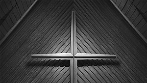 Wandkreuz in einer Kirche, schwarz-weiß | © Joshua Eckstein, unsplash.com