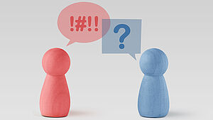 Rosa und hellblaue Spielfigur, die durch Sprechblasen einen Streit darstellen. | © shutterstock.com