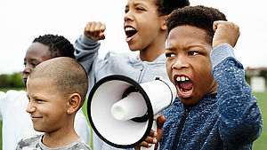 Junge schreit in ein Megaphon in einem Protest. | © Rawpixel.com