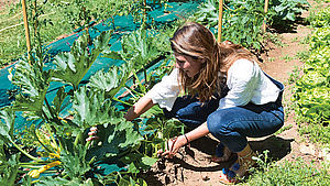 Caleigh Megless-Schmidt im Gemüsebeet | © Sandra Mahut