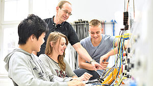 Mann zeigt 3 Jugendlichen etwas an einer Maschine | © industryviews / shutterstock.com