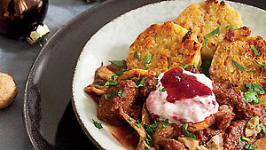 Wildragout mit Knödeln, angerichtet auf Teller. | © Enikö Gruber