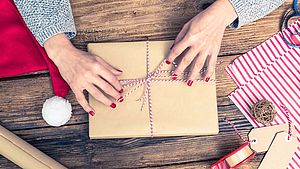 Eine Frau packt Weihnachtsgeschenke ein | © Marcin Jucha, Shutterstock.com