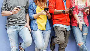 Gruppe junger Menschen schaut auf ihr Smartphone | © DisobeyArt