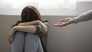 Weinendes Mädchen mit Kopf in den Armen versteckt, von rechts entgegengestreckte Hand der Mutter. | © shutterstock.com