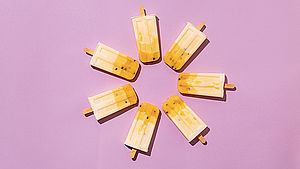 Sieben selbstgemachte Eis am Stiel liegen im Kreis auf einem rosa Hintergrund. | © Julia Cawley